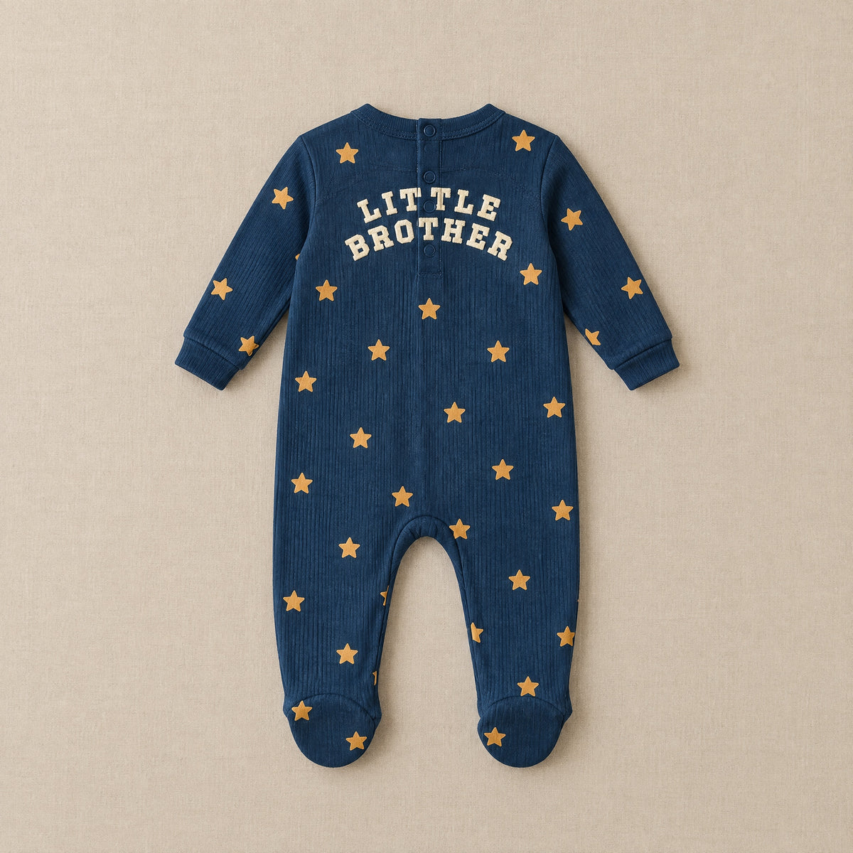 Navy star footed sleepsuit, back, laid flat, LITTLE BROTHER in cream letters