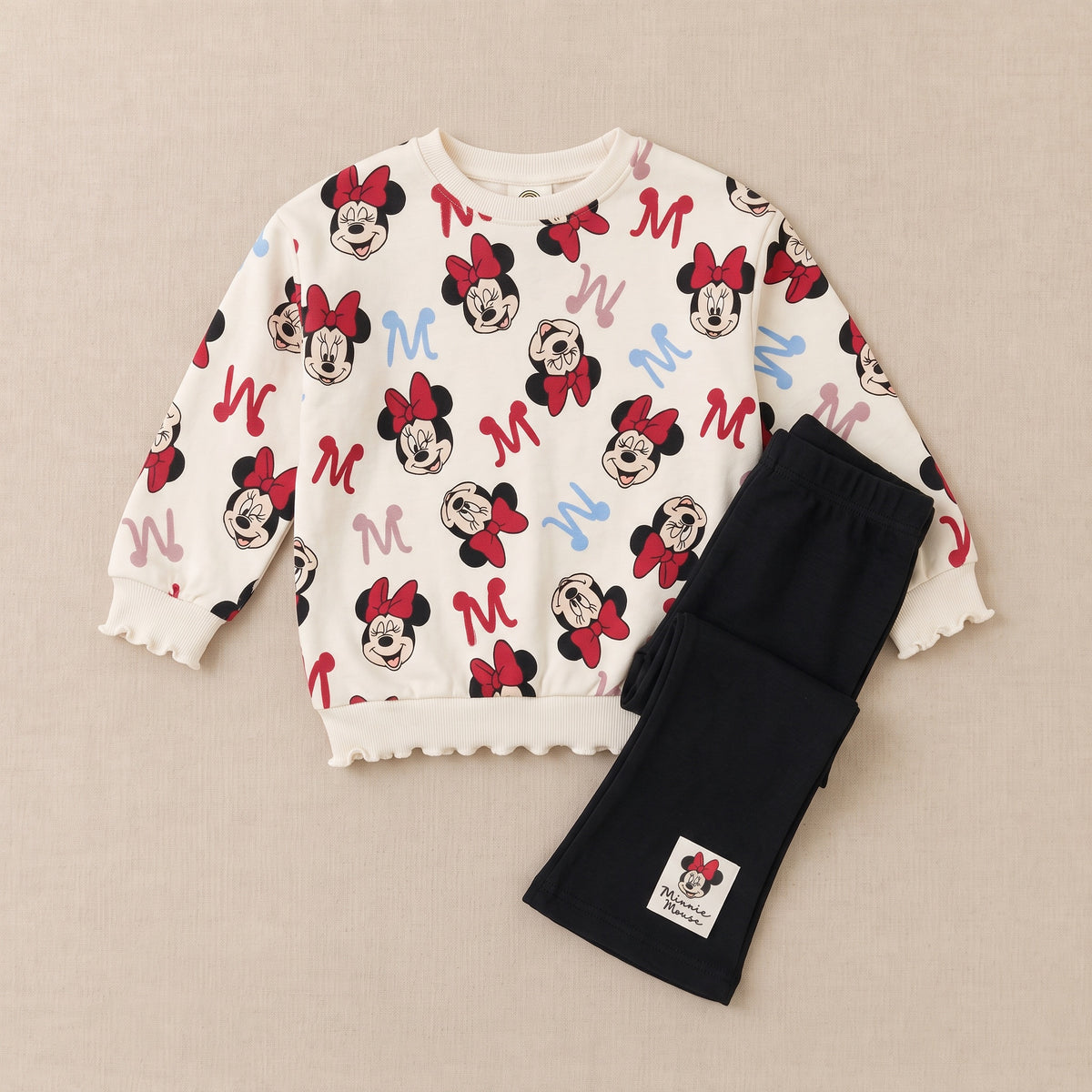 Mouse print sweatshirt and black flared trousers laid flat, front