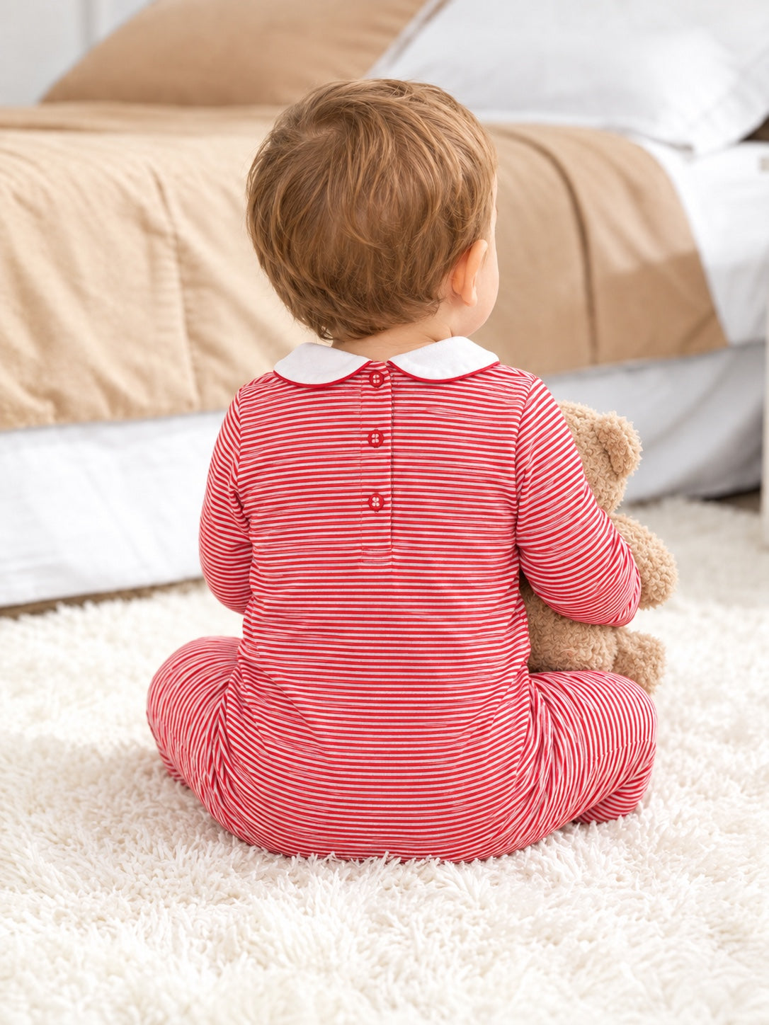 Baby sitting in the red-stripe soldier sleepsuit, back view showing the collar and back opening