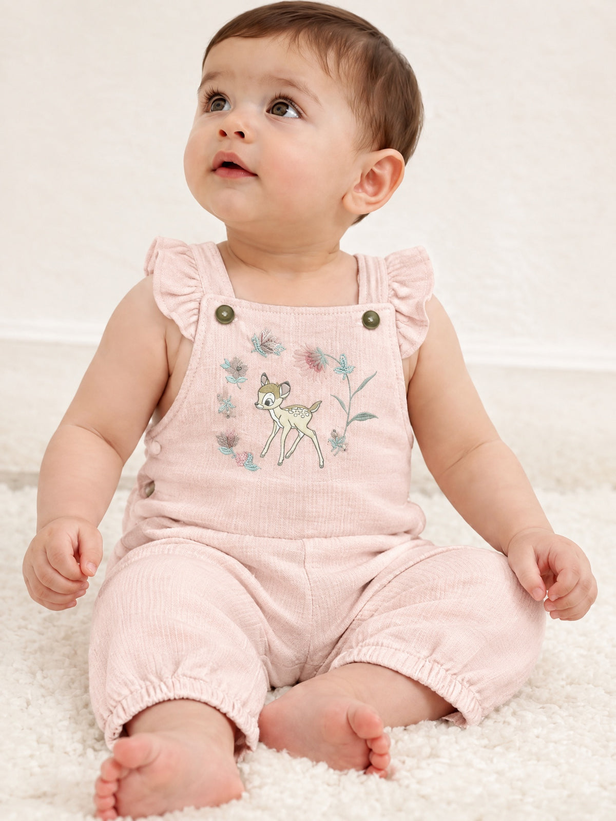 Baby sitting in the Little Fawn dungarees, front