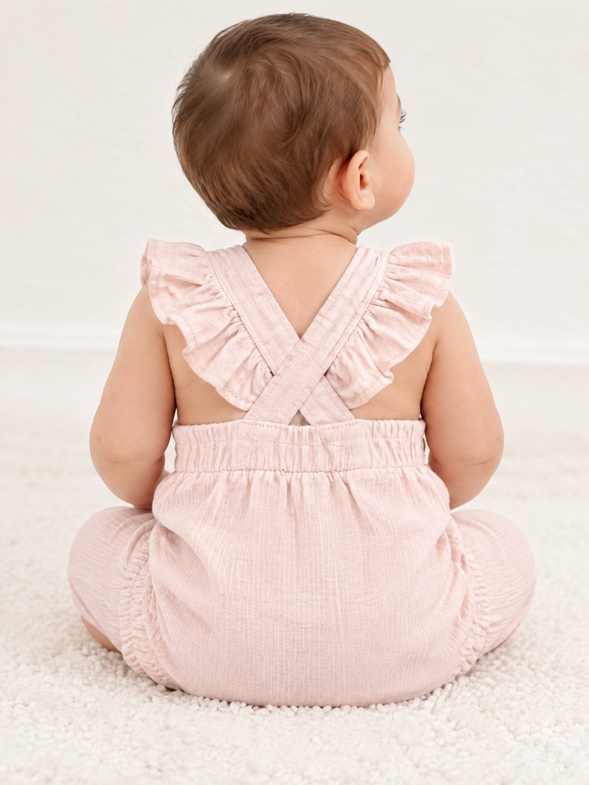 Baby in the Little Fawn dungarees, back with crossed frilled straps