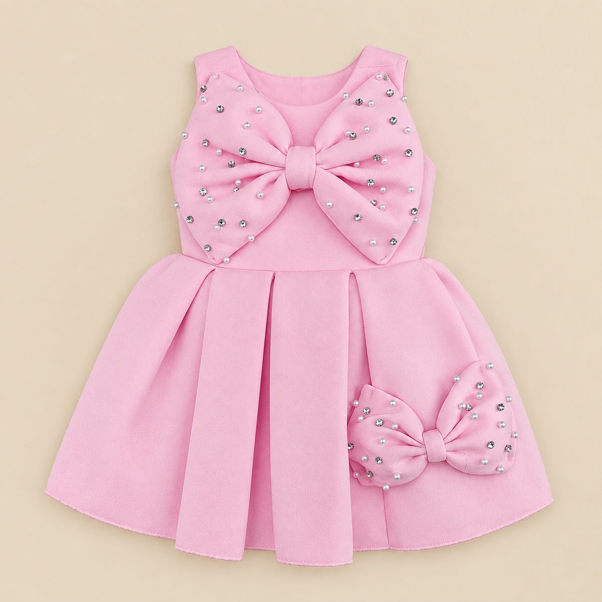 Pink frock laid flat, pearl bow at the chest and a small bow on the skirt